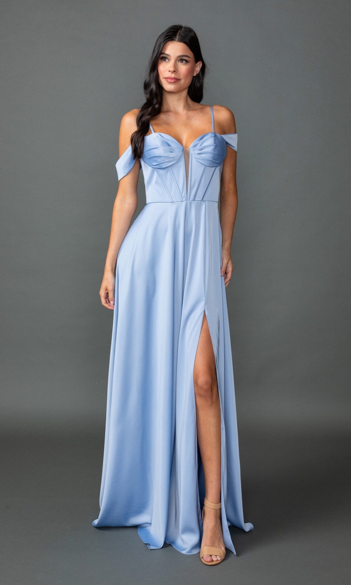 A woman models the Dancing Queen 4544 long prom dress in light blue, featuring spaghetti straps, an off-the-shoulder neckline, and a thigh-high slit, standing before a plain gray background.